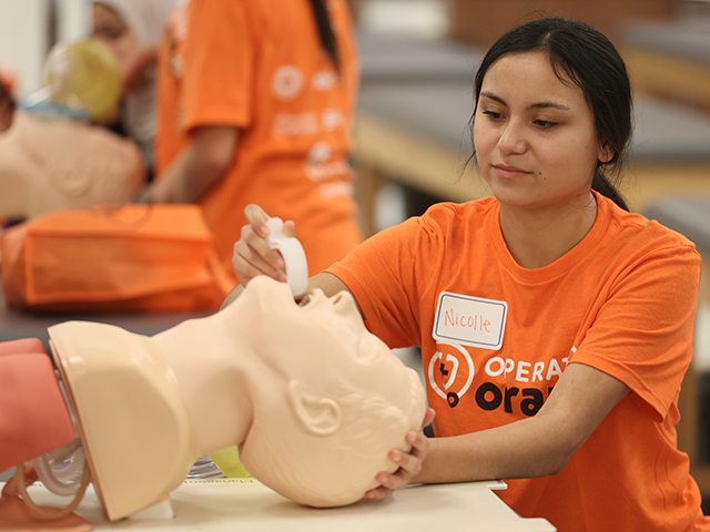 High school med school prospect participating in the airway management station at Operation Orange in Tulsa, Oklahoma.